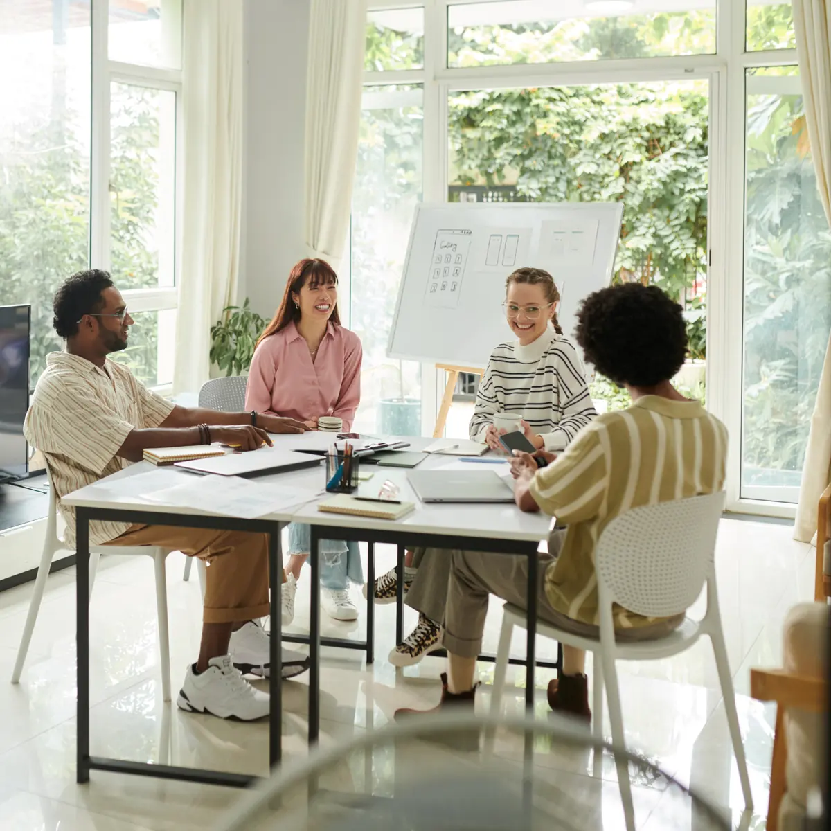 A small team laughing together at a workshop table
